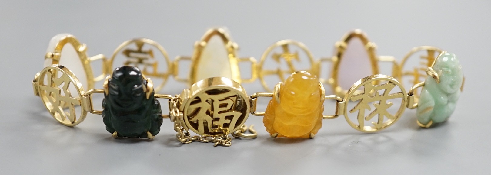 A Chinese 14k yellow metal and hardstone set bracelet, with alternating character and six carved Buddha set links, approx. 17cm, gross weight 17.3 grams.